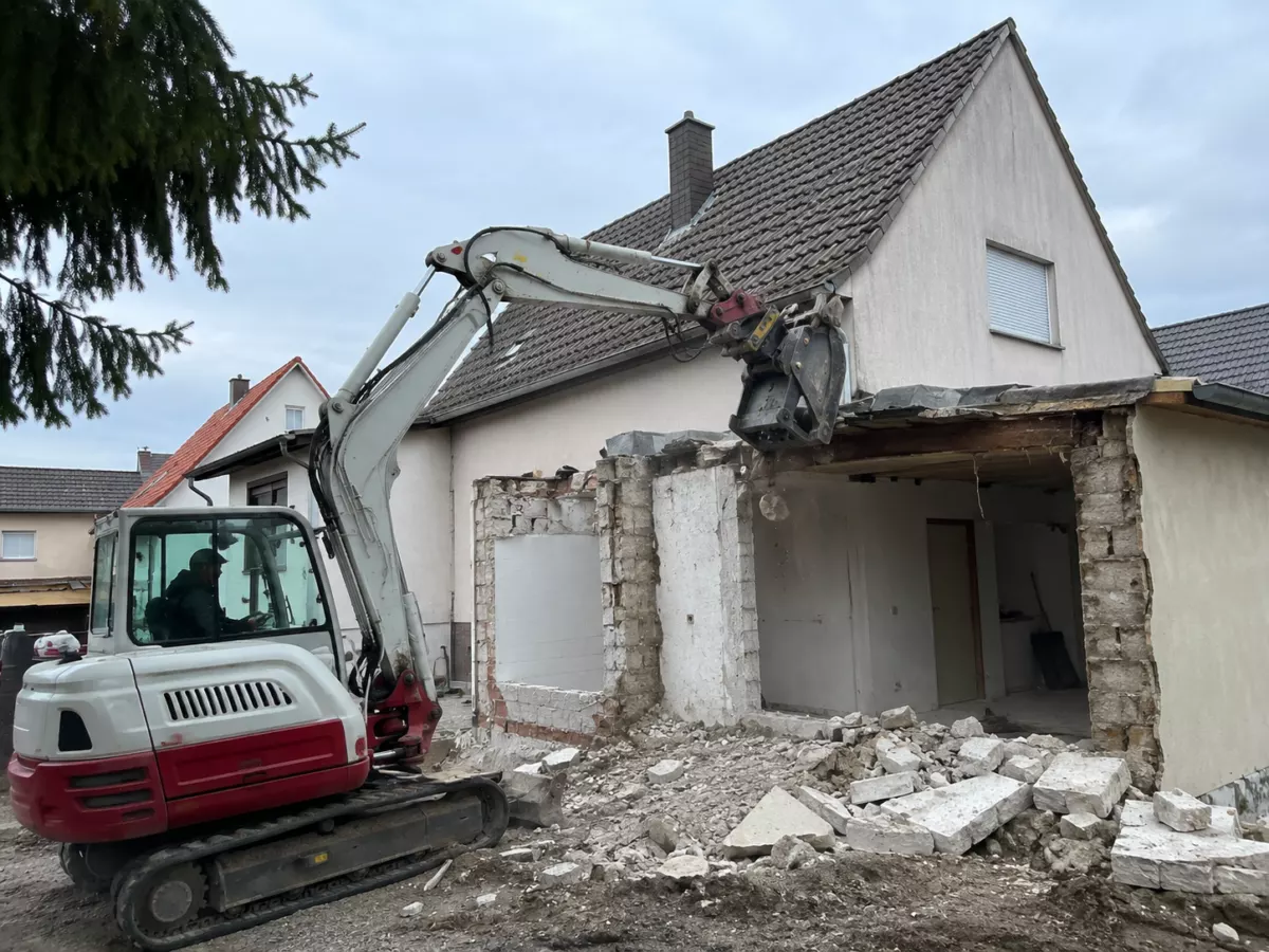 Bagger beim kontrollierten Abriss eines Hauses im Rahmen von Abbrucharbeiten durch MH BauPlus+.